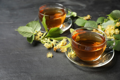 Photo of Tasty tea and linden blossom on black table