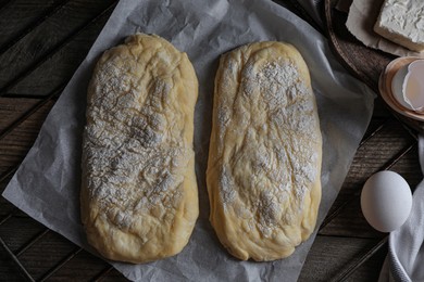Photo of Raw dough for ciabatta and flour on wooden table, flat lay
