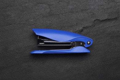 New bright stapler on black table, top view. School stationery