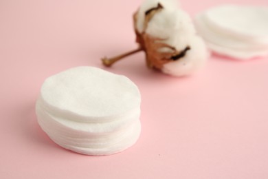 Photo of Cotton pads and flower on pink background, closeup