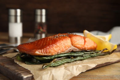 Photo of Tasty cooked salmon and vegetables served on wooden table. Healthy meals from air fryer