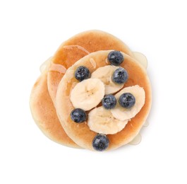 Photo of Delicious pancakes with banana slices, blueberries and honey isolated on white, top view