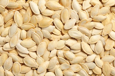 Photo of Many pumpkin seeds as background, top view