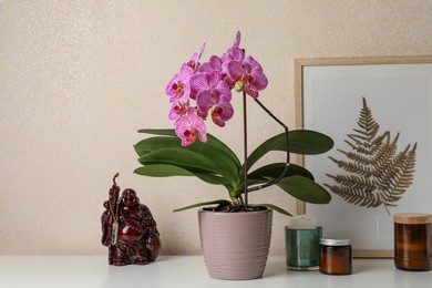 Photo of Beautiful pink orchid flower and different decor elements on white table