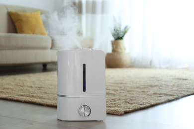 Modern air humidifier on floor indoors. Space for text