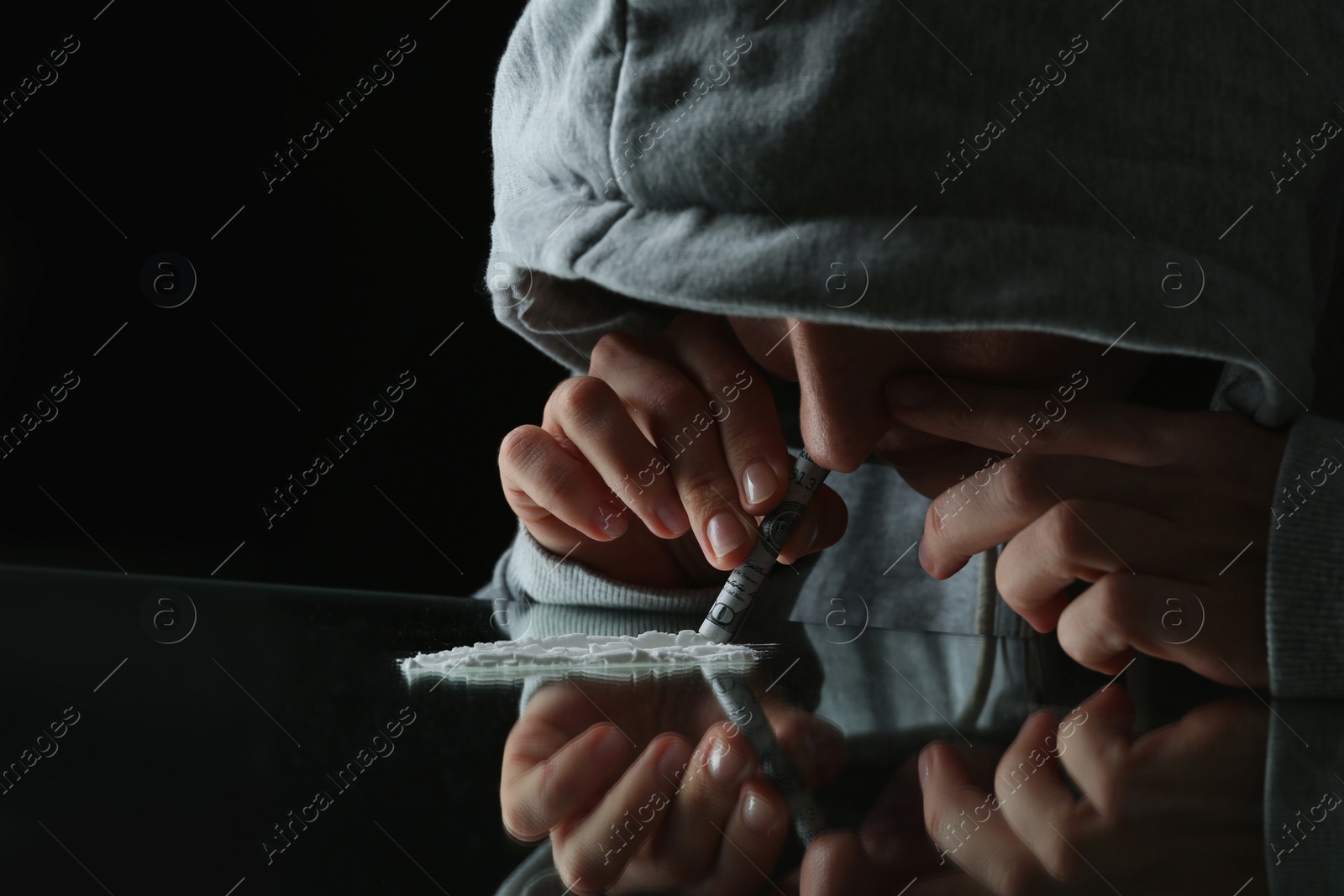 Photo of Drug addict taking cocaine at table, closeup view