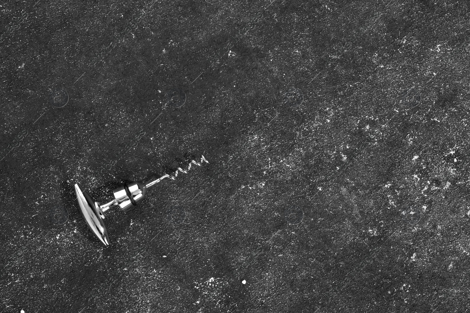 Photo of One corkscrew on grey textured table, top view. Space for text