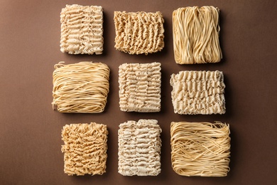 Flat lay composition with different quick cooking noodles on color background