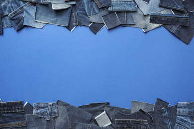 Photo of Frame made of cut jeans on blue background, top view. Space for text