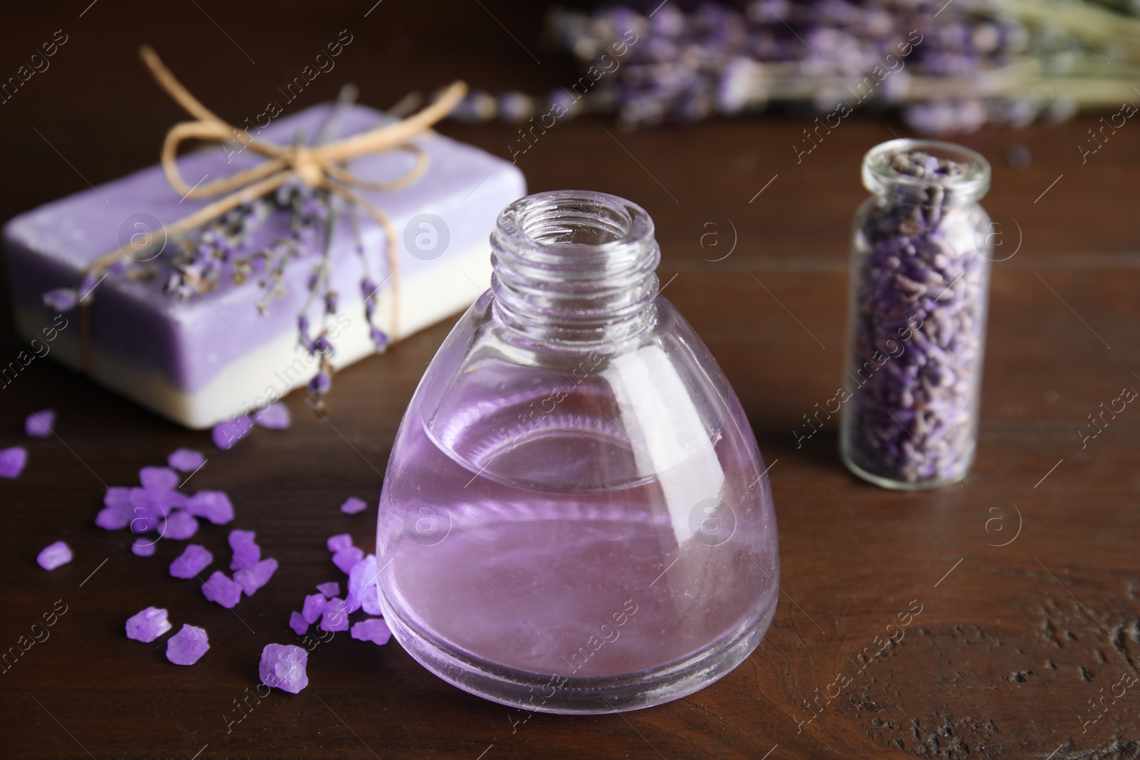 Photo of Bottle with aromatic lavender oil on wooden table