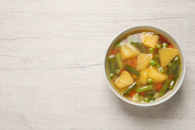 Photo of Bowl of delicious turnip soup on wooden table, top view. Space for text