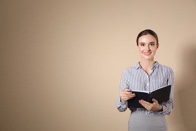 Portrait of young female teacher on beige background. Space for text