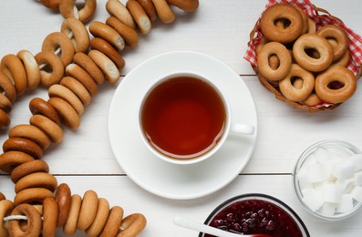 Flat lay composition with delicious ring shaped Sushki (dry bagels) and cup of tea on white wooden table
