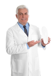 Photo of Male orthopedist showing insole on white background