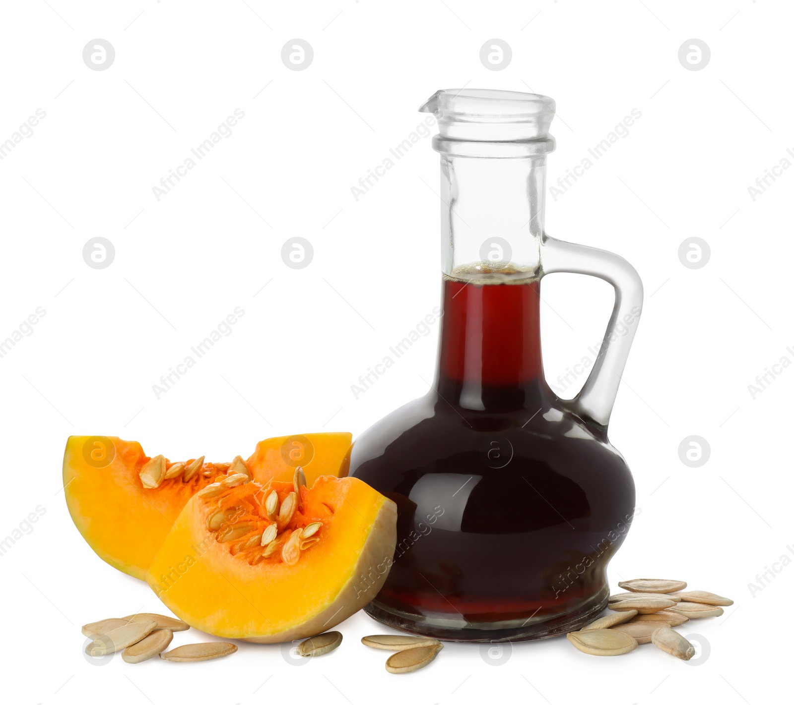 Photo of Fresh pumpkin seed oil in glass jug isolated on white