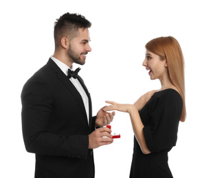 Photo of Man with engagement ring making marriage proposal to girlfriend on white background