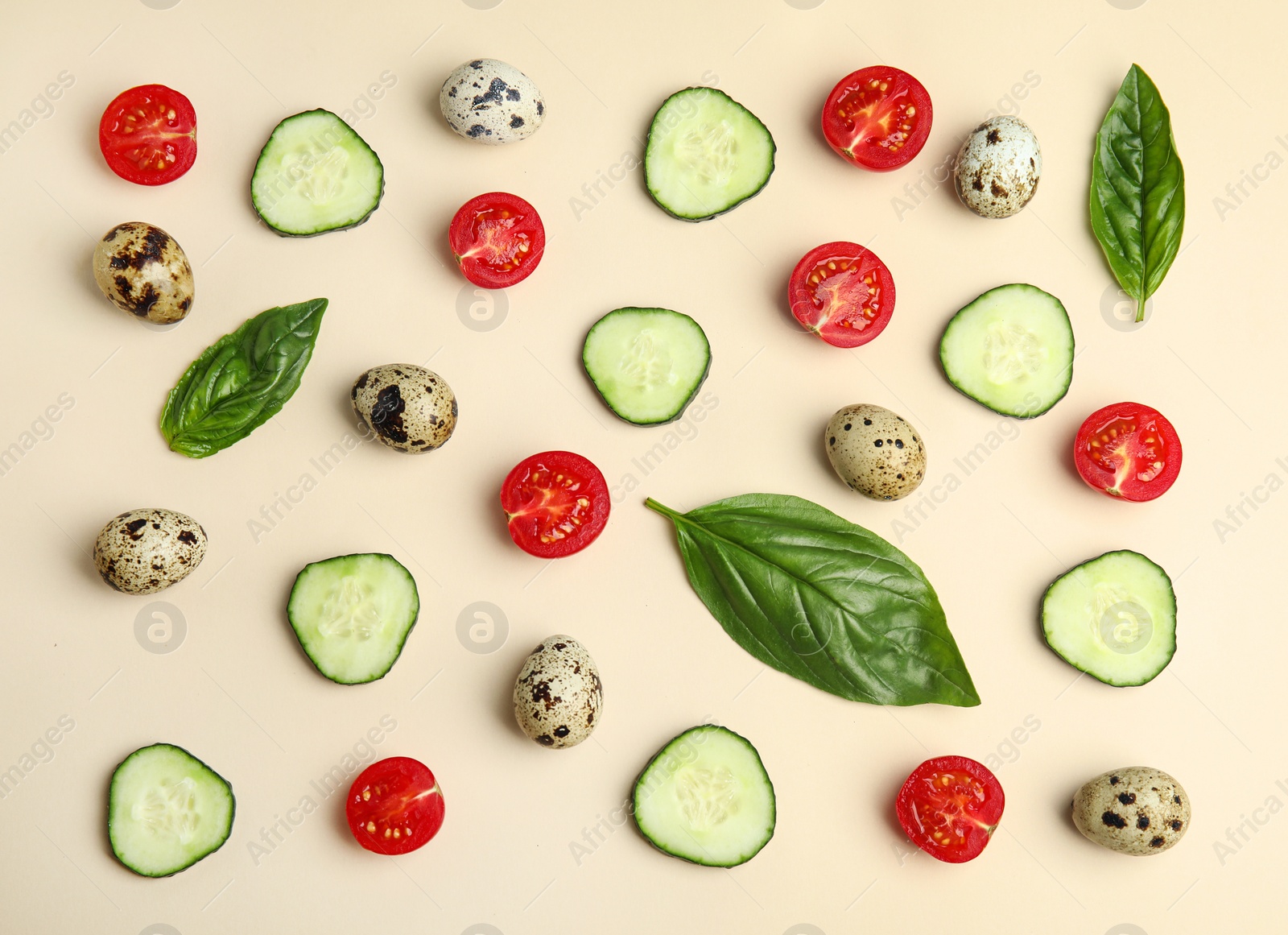 Photo of Fresh vegetables and quail eggs on beige background, flat lay