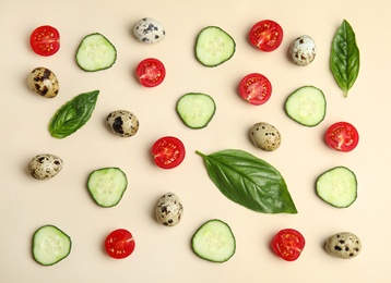 Fresh vegetables and quail eggs on beige background, flat lay