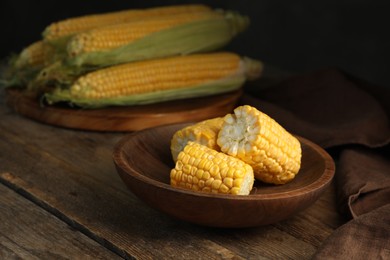 Tasty sweet corn cobs on wooden table