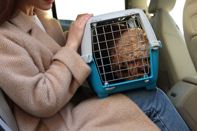 Photo of Woman with pet carrier travelling with dog her by car, closeup