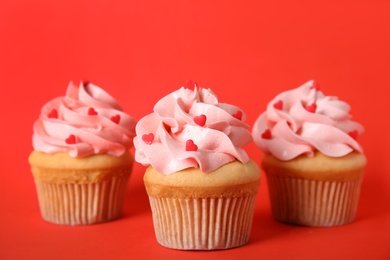 Photo of Tasty cupcakes for Valentine's Day on red background
