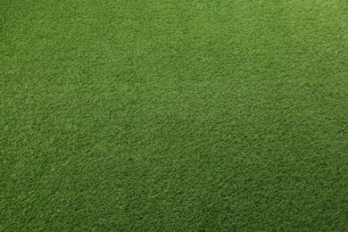 Photo of Green artificial grass as background, top view