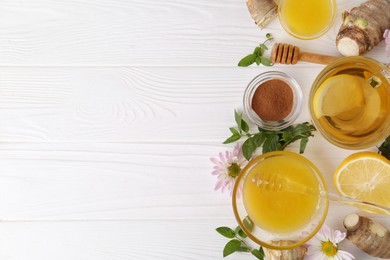 Flat lay composition with cup of delicious tea, honey and ginger on white wooden table. Space for text