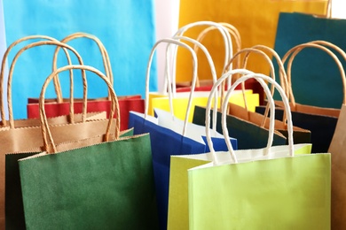 Photo of Colorful paper shopping bags as background, closeup