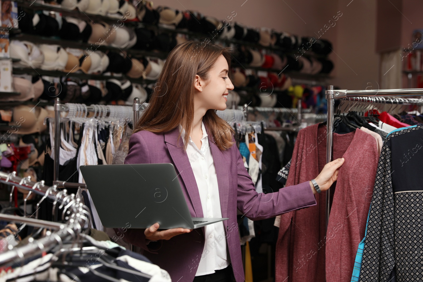 Photo of Young business owner with laptop in boutique