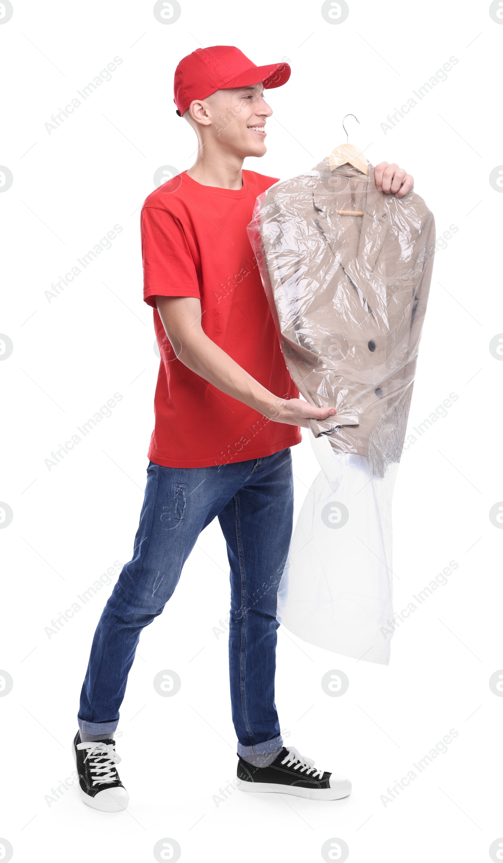 Photo of Dry-cleaning delivery. Happy courier holding jacket in plastic bag on white background