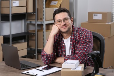 Seller with laptop at workplace in office. Online store