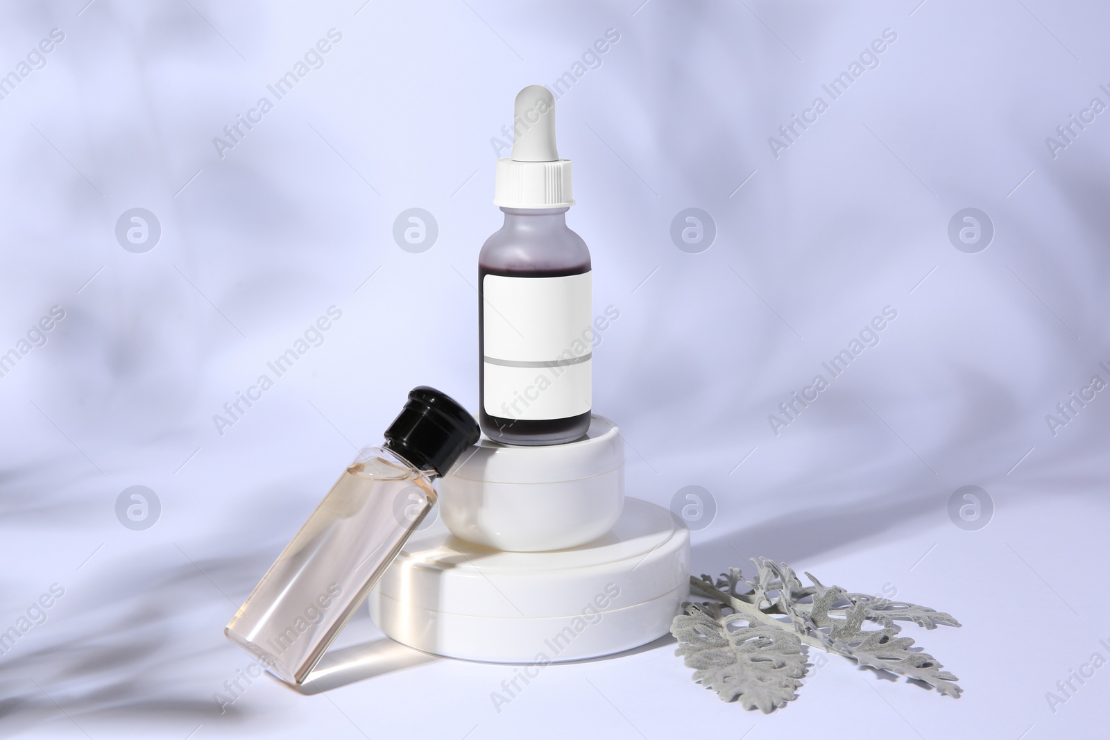 Photo of Cosmetic products and silver leaves on white background