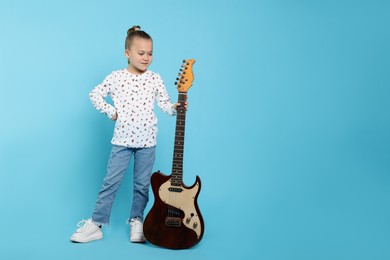 Happy girl with electric guitar on turquoise background. Space for text