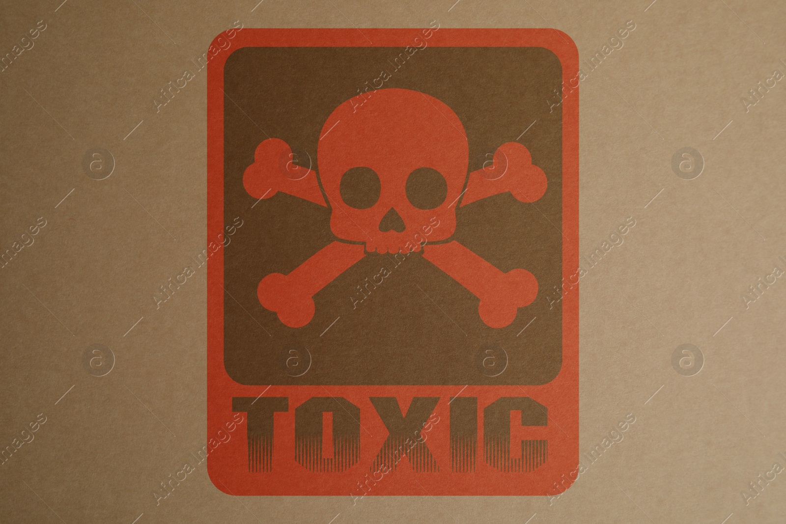 Image of Hazard warning sign (skull-and-crossbones symbol and word TOXIC) on kraft paper, top view