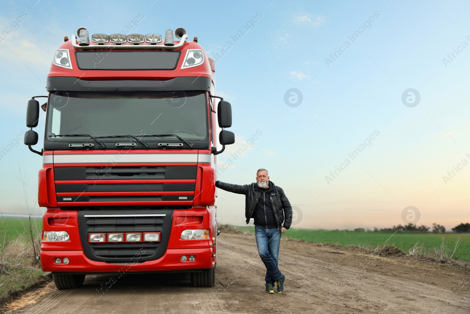 Photo of Portrait of mature driver closing door of modern truck outdoors