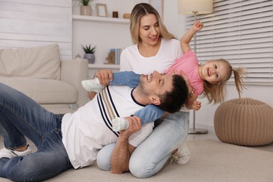 Photo of Family with little daughter spending time together at home