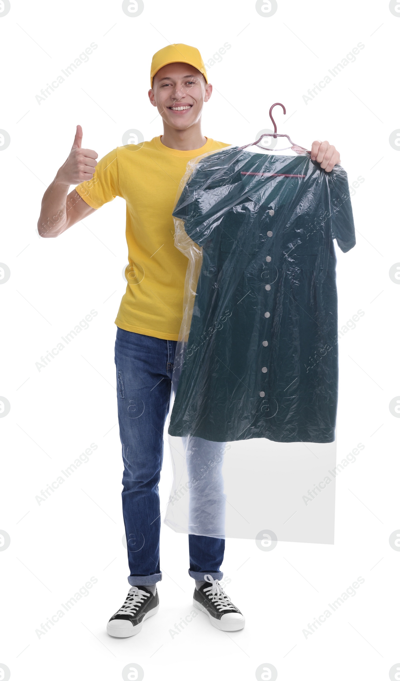 Photo of Dry-cleaning delivery. Happy courier holding dress in plastic bag and showing thumbs up on white background
