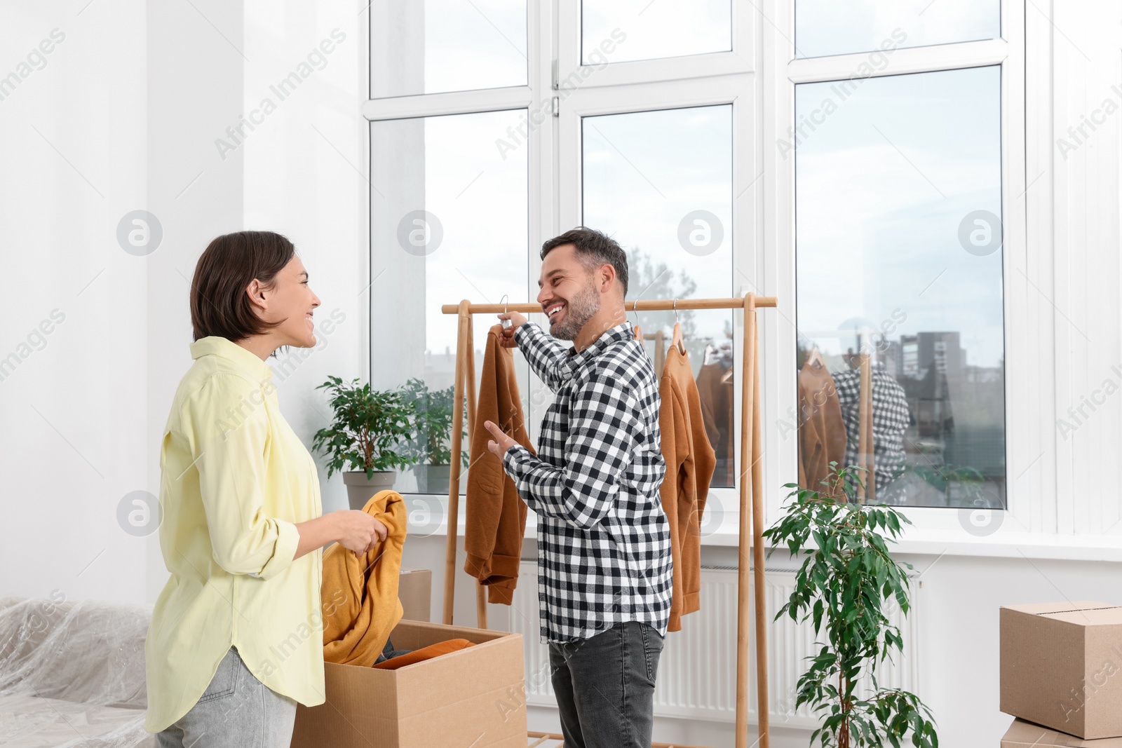 Photo of Happy couple unpacking box in new apartment. Moving day