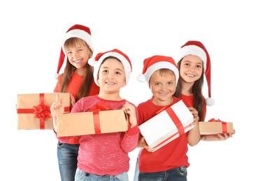 Cute little children in Santa hats with Christmas gifts on white background