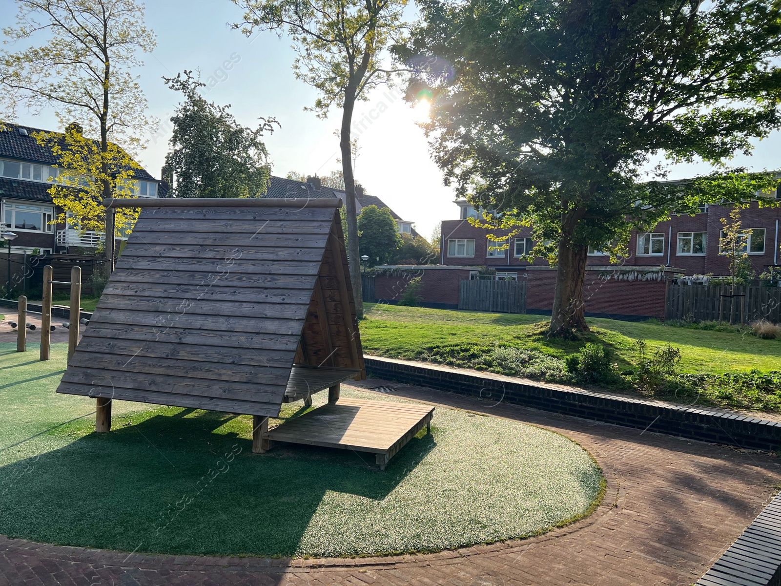 Photo of Outdoor playground for children with small wooden house on sunny day