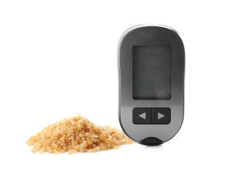 Photo of Digital glucometer and brown sugar on white background. Diabetes concept