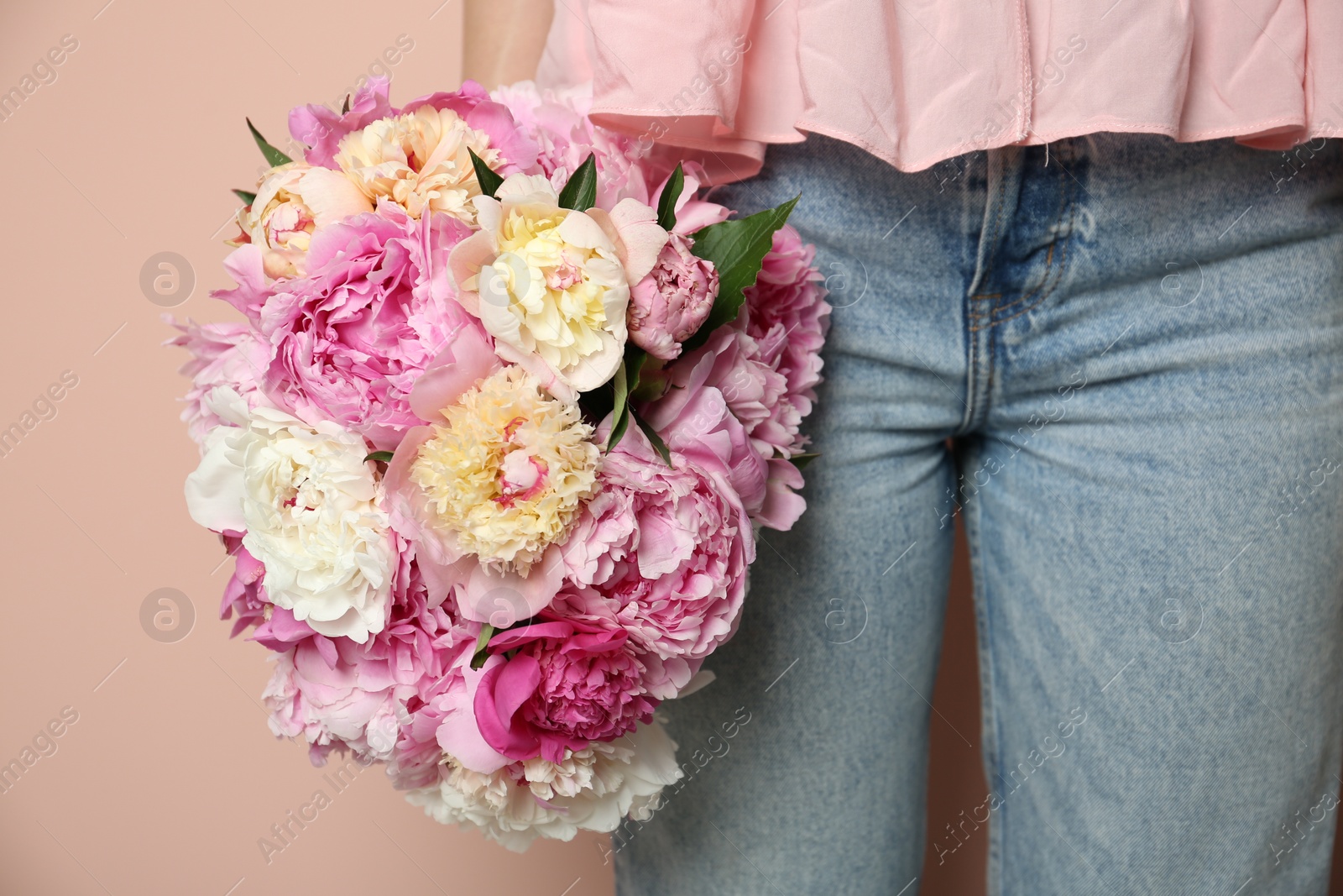 Photo of Woman with bouquet of beautiful peonies on beige background, closeup