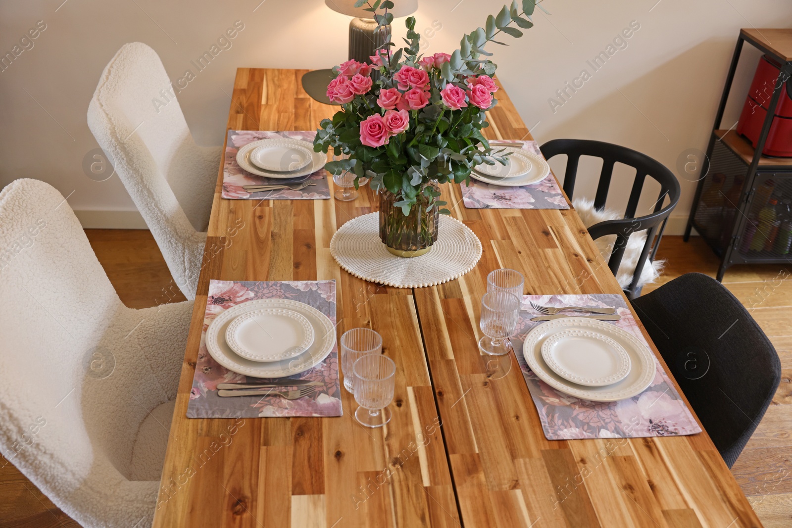 Photo of Beautiful table setting with bouquet indoors. Roses and eucalyptus branches in vase