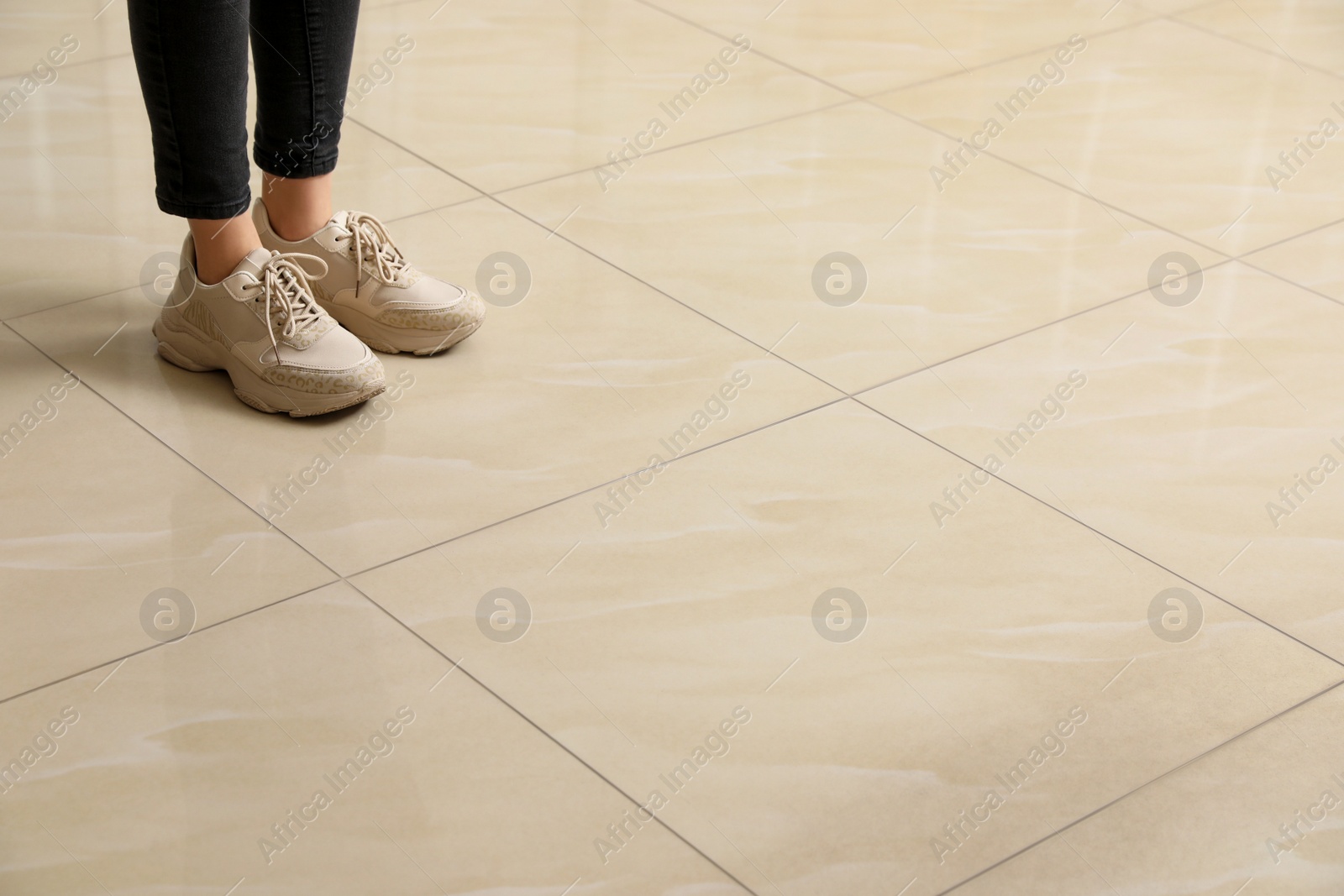 Photo of Woman standing on ceramic floor, closeup. Space for text