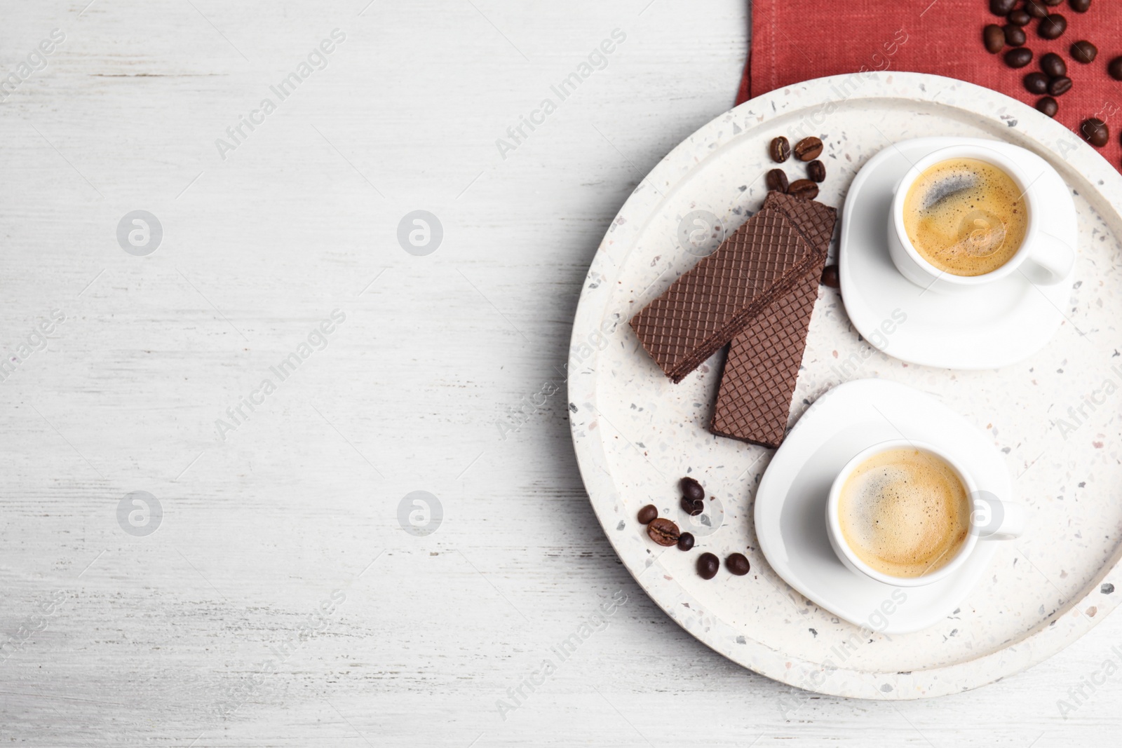 Photo of Breakfast with delicious wafers and coffee on white wooden table, top view. Space for text