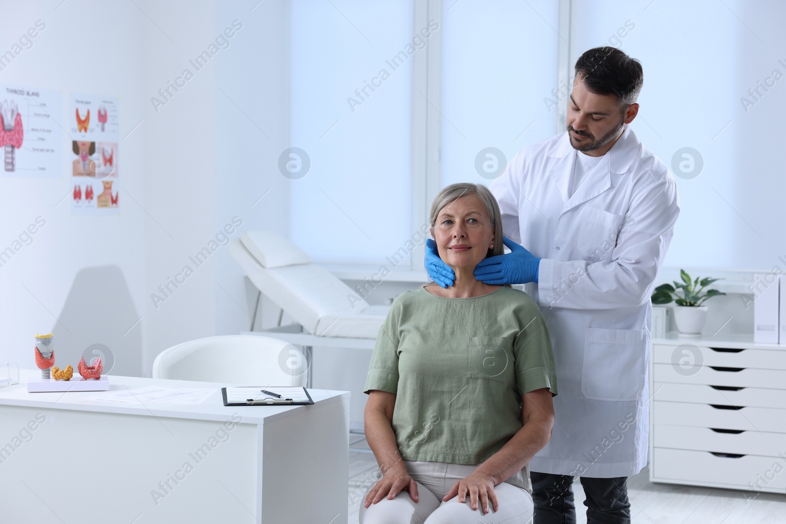 Photo of Endocrinologist examining thyroid gland of patient at hospital. Space for text