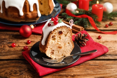 Photo of Composition with piece of traditional homemade Christmas cake on wooden table, closeup