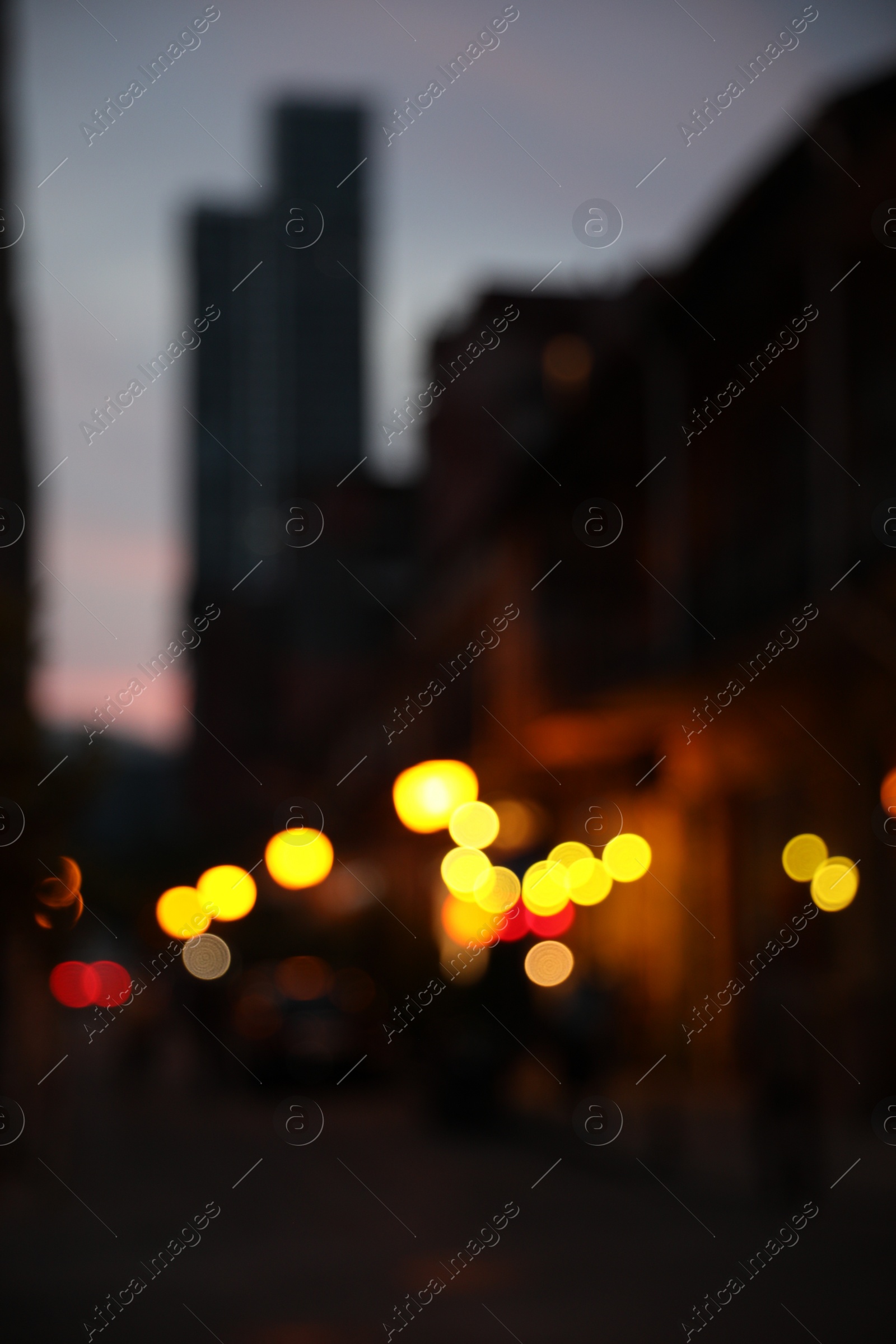 Photo of Blurred view of beautiful cityscape with glowing streetlights and illuminated building in evening