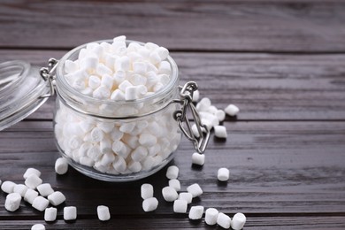 Glass jar with delicious marshmallows on wooden table, closeup