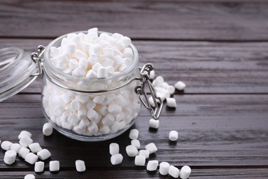 Photo of Glass jar with delicious marshmallows on wooden table, closeup